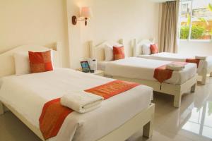 a hotel room with two beds in a room at Grandsmile Wellness Resort in Pattaya Central