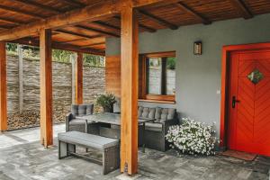 a patio with a table and chairs and a red door at Skrzaci zakątek - domek z prywatną balią z jacuzzi in Stronie Śląskie