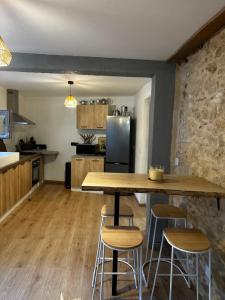 eine Küche mit einem Holztisch und Stühlen in der Unterkunft Charmante maison de 4 chambres in Bergerac
