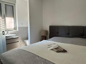 a bed with a towel on it with a sink and a bathroom at Zavala Residence in Zavala