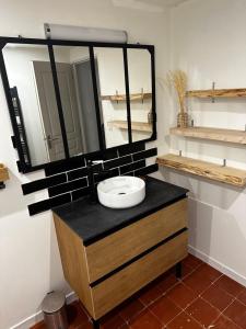 ein Badezimmer mit Waschbecken und Spiegel in der Unterkunft Charmante maison de 4 chambres in Bergerac