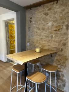ein Holztisch mit Hockern vor einer Steinmauer in der Unterkunft Charmante maison de 4 chambres in Bergerac + 16 Fotos
