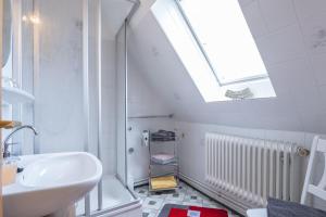 a bathroom with a sink and a skylight at Ferienwohnungen Engelmann, 35107 in Holtland +60 photos