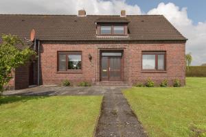 a brick house with a grass yard in front of it at Ferienhaus Waldblick, 35209 in Hesel