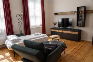 a living room with a couch and a tv at Apartmenthaus Gutenberg 78 in Potsdam