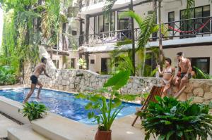 a group of men playing in a swimming pool at Departamentos en SF - Adults Only in Playa del Carmen