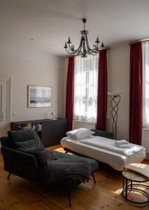 a bedroom with a bed and a couch and red curtains at Apartmenthaus Gutenberg 78 in Potsdam