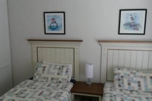 En eller flere senge i et værelse på Goosevalley Golf Estate Renovated 2 Bedroom Apartment Unit LL6