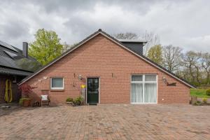 a red brick house with a brick driveway at Ferienwohnung Birken Allee, 35181 in Schwerinsdorf