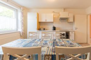 a kitchen with a table and chairs in a room at Ferienwohnung Am Walde 35177 in Hesel