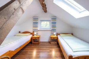 two beds in a attic bedroom with skylights at Ferienwohnung Birken Allee, 35181 in Schwerinsdorf