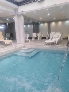 a large swimming pool with chairs and a table at Suite La Posta in San Salvador de Jujuy