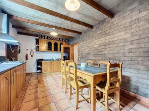 a kitchen with a wooden table and chairs at Casa da Palmeira in Machico