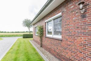 a brick building with a window and a plant at Ferienwohnung Landleben 35195 in Hesel