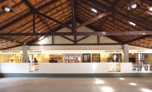 a large building with wooden ceilings and a store at Rancho do Zé João in Lavrinhas