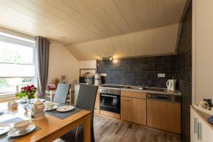 a kitchen with a wooden table and a dining room at Ferienwohnung Hillers, 35218 in Beningafehn