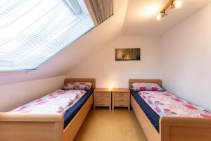 two beds in a room with two windows at Ferienwohnung Hillers, 35218 in Beningafehn