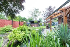 a garden with a pond and a wooden pavilion at Ferienwohnung Hillers, 35218 in Beningafehn