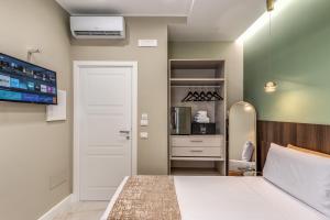 a bedroom with a white bed and a white door at Le stanze di Venere in Naples