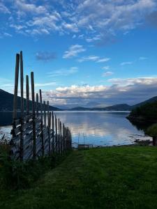 a fence on the side of a body of water at Kræmarvika Vila in Tromsø