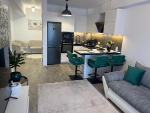 a living room with a couch and a kitchen at Apartament Prima Arena in Oradea +9 photos