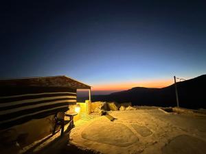 达纳达纳塔酒店的夕阳下的雪地里的一张桌子和一把椅子