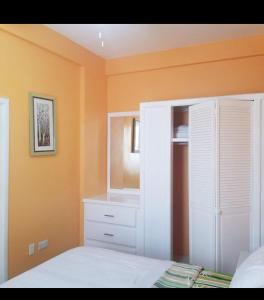 una camera con letto e armadietto bianco di La Bwizan Apt # 2 a Laborie