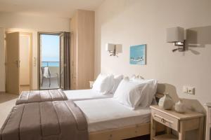 a bedroom with a bed with a view of the ocean at Malliotakis Beach Hotel "by Checkin" in Stalida