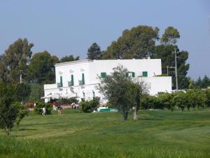 biały budynek na szczycie zielonego pola w obiekcie Golf Club Metaponto w mieście Metaponto