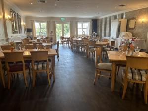 a dining room with wooden tables and chairs at Drummond Hotel in Ballykelly