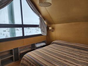 a bedroom with a bed and a large window at Pueblo Andino in Malargüe