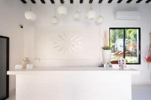 a white kitchen with a clock on the wall at Saastah Hotel Boutique in Valladolid