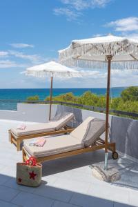 two beds on a roof with an umbrella and the ocean at Acquamarina Apartment in Rivabella