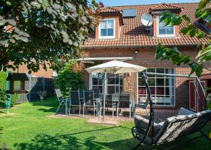 a patio with an umbrella and chairs in a yard at Ferienhaus Eisenach in Eisenach
