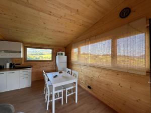 a kitchen with a table and chairs in a cabin at Domki- Limanowa domek 3 domek z jacuzzi i sauną in Limanowa