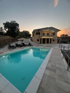 ein großer blauer Swimmingpool vor einem Haus in der Unterkunft Villa delle Meraviglie in Boville Ernica