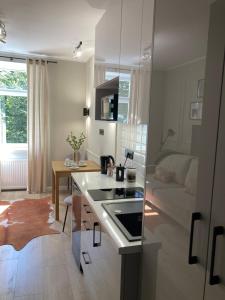 a kitchen and living room with a table and a couch at Nowe studio blisko Atlas Areny in Łódź