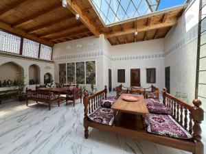 een grote woonkamer met een tafel en stoelen bij Grand Emir Residence in Bukhara