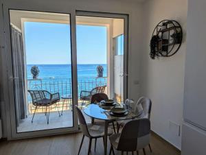 a dining room with a table and a view of the ocean at Alema apartment Giardini Naxos in Giardini Naxos