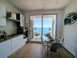 a kitchen with a table and a view of the ocean at Alema apartment Giardini Naxos in Giardini Naxos