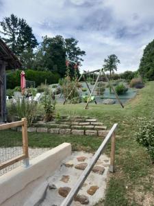 un'altalena in un giardino con un laghetto di La maison family a Veaugues