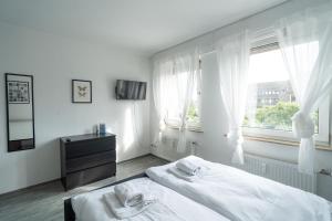 a white bedroom with a bed and a window at Wohnung im Zentrum von Koblenz in Koblenz
