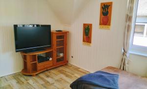 a living room with a television on a wooden stand at Ferienwohnung am Nürburgring 2.OG in Adenau
