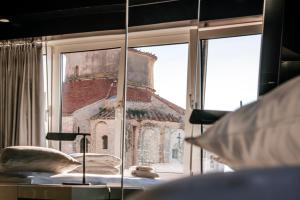 a bedroom with a view of a building through a window at Boutique Hostel Forum in Zadar