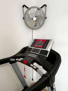 Una cinta de correr con un ventilador fijado a una pared en Fit-House Fuerteventura Wifi & Gym, en Puerto del Rosario