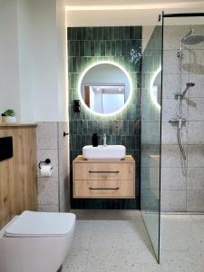 a bathroom with a toilet and a sink and a shower at Apartamenty K17 Stare Miasto in Malbork +148 photos