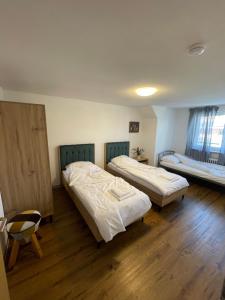 two beds in a room with wooden floors at Era Home in Murg