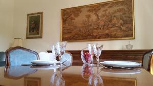a dining room table with glasses and a painting on the wall at Domus al Palatino in Rome