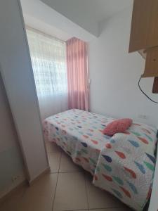 een kleine slaapkamer met een bed en een raam bij El balcón de Nerja in Nerja