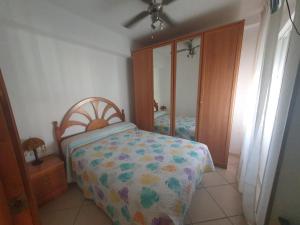 een slaapkamer met een bed, een ladekast en een spiegel bij El balcón de Nerja in Nerja
